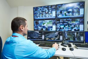 Man monitoring video surveillance systems