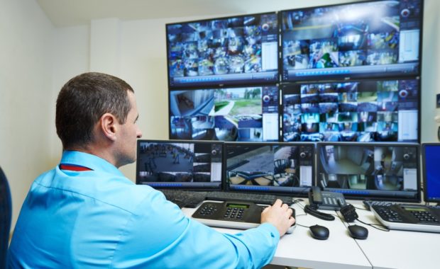 Man monitoring video surveillance systems